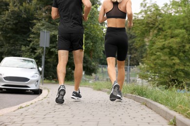 Photo of Healthy lifestyle. Sporty couple running outdoors, closeup