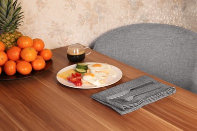 Photo of Tasty toasts with fried eggs, cheese and vegetables on wooden table indoors