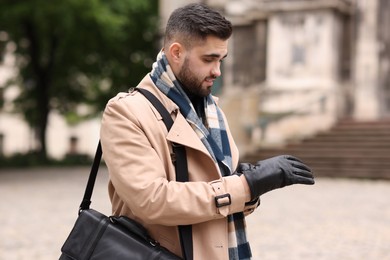 Handsome man in warm scarf on city street