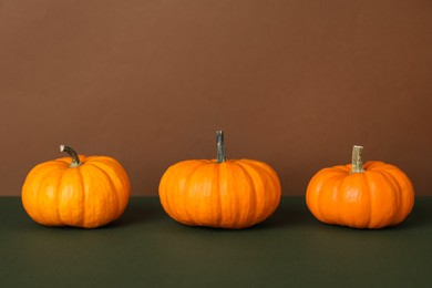 Photo of Fresh ripe pumpkins on color background, space for text
