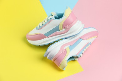 Photo of Pair of stylish bright sneakers on color background