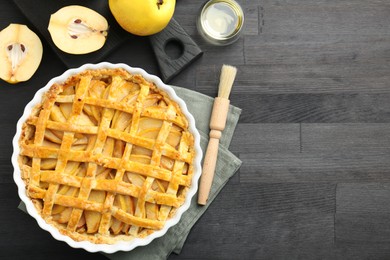 Photo of Tasty homemade quince pie and fresh fruits on black wooden table, flat lay. Space for text