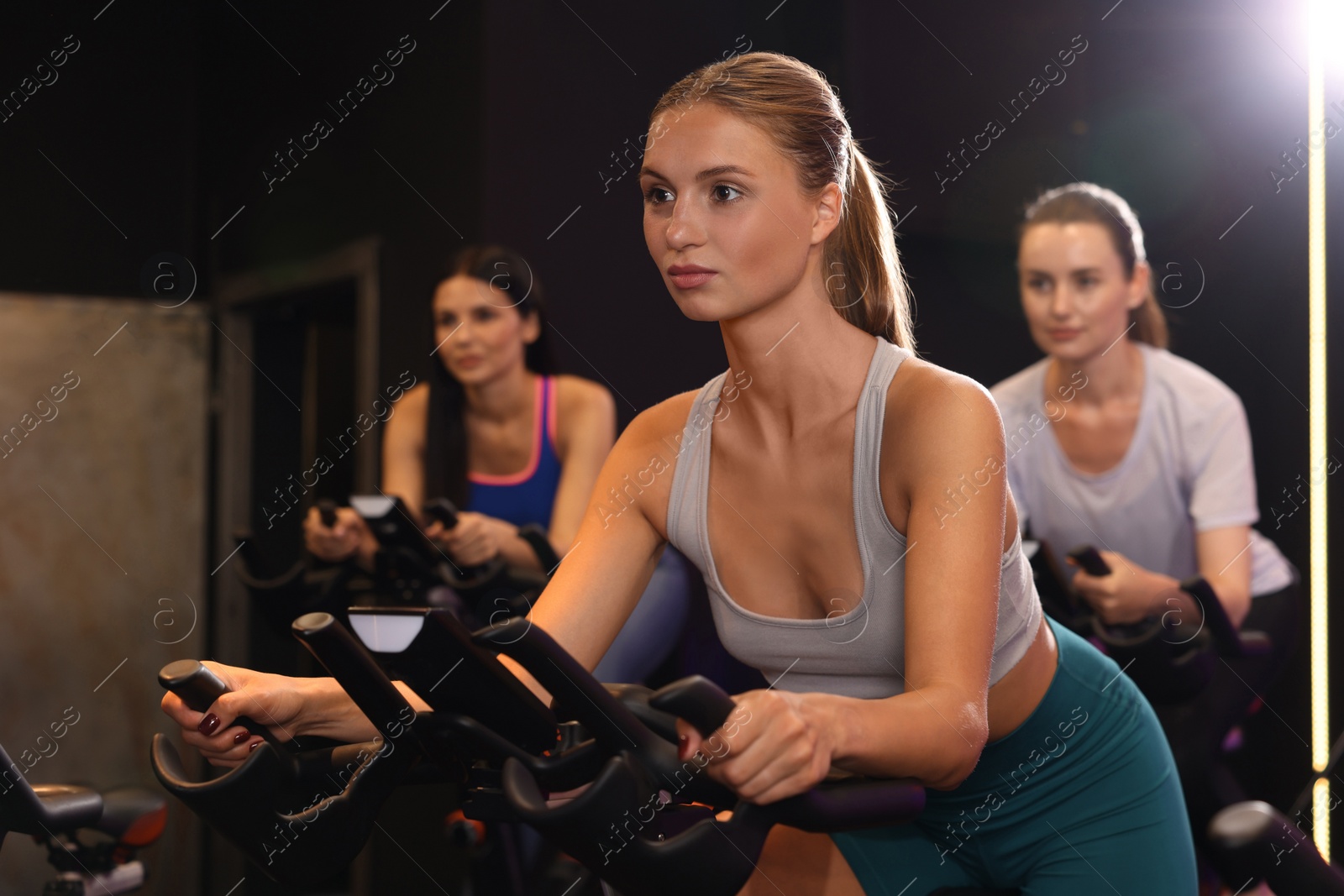 Photo of Group of women training on exercise bikes in fitness club