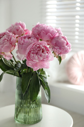 Photo of Bouquet of beautiful peonies on table indoors