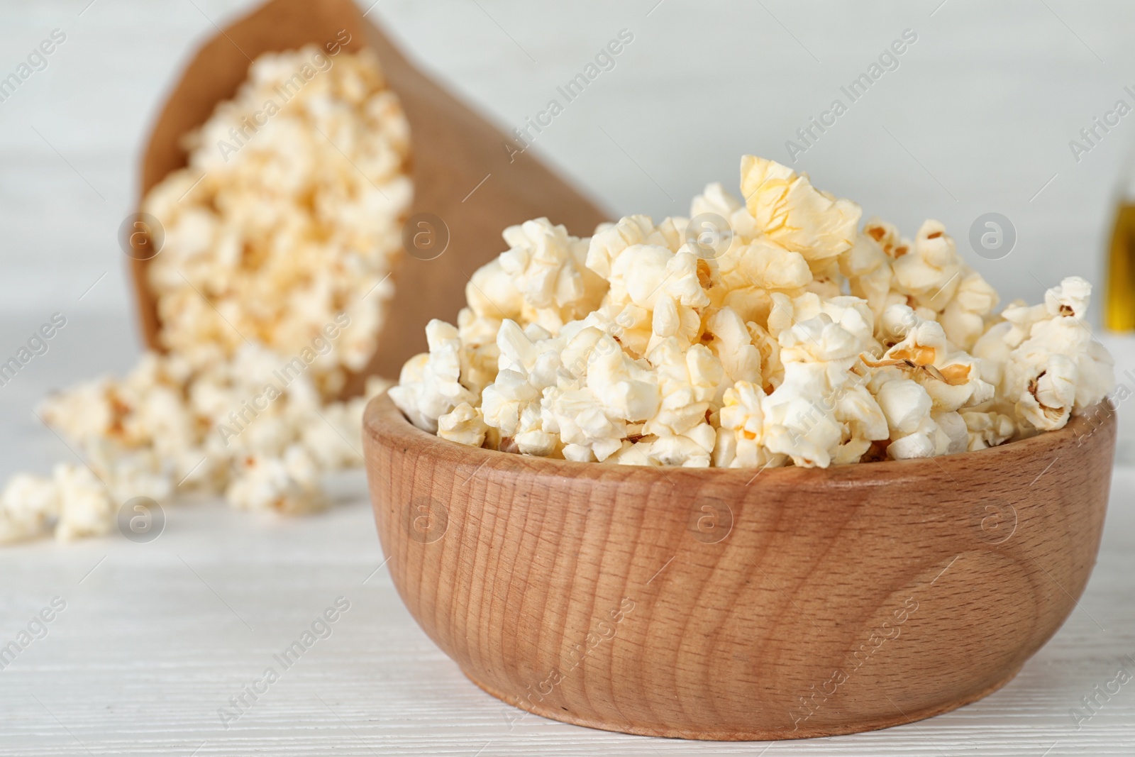 Photo of Wooden bowl with tasty popcorn on table