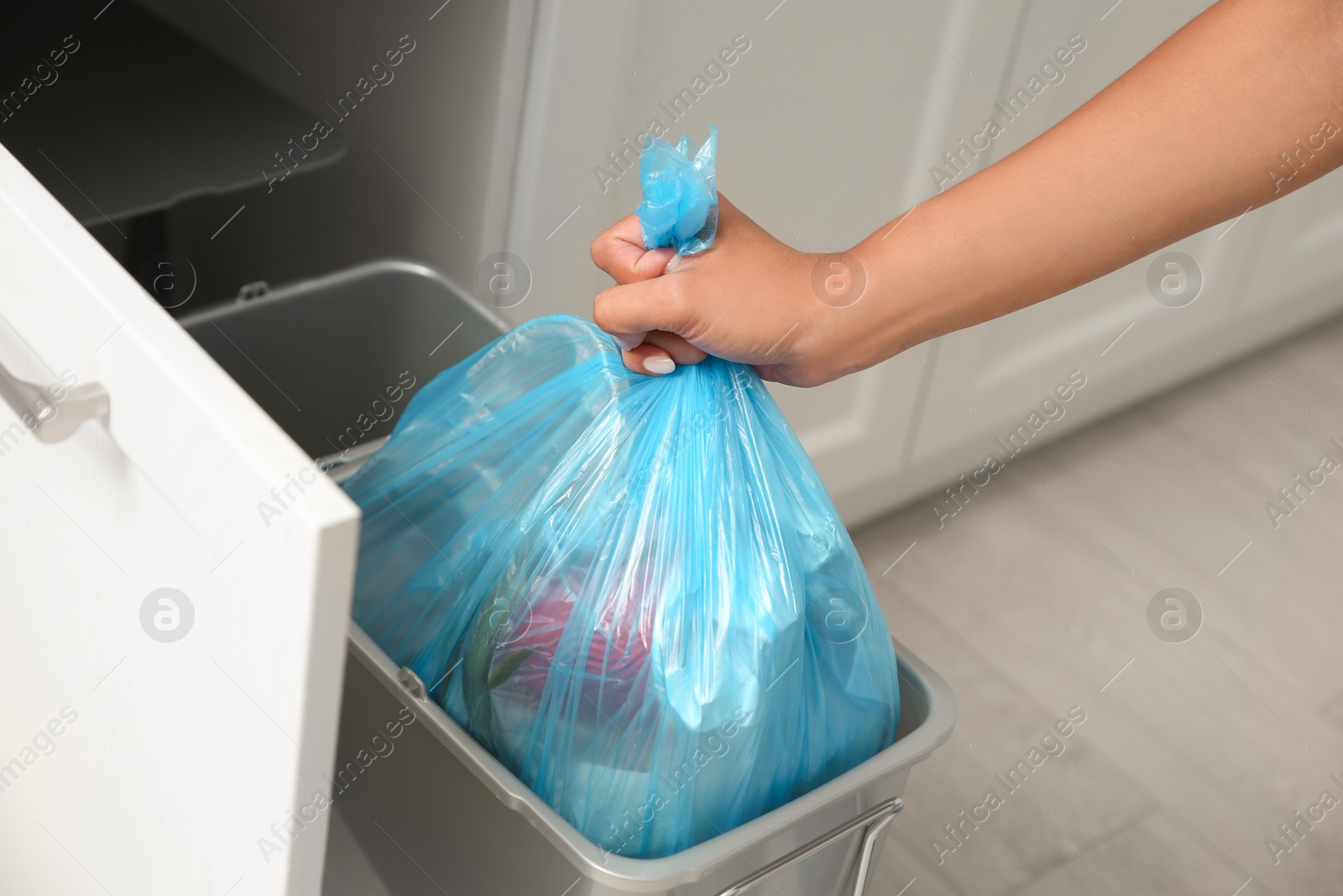 Photo of Woman taking garbage bag out of bin at home, closeup