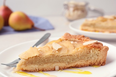 Piece of delicious sweet pear tart on table, closeup