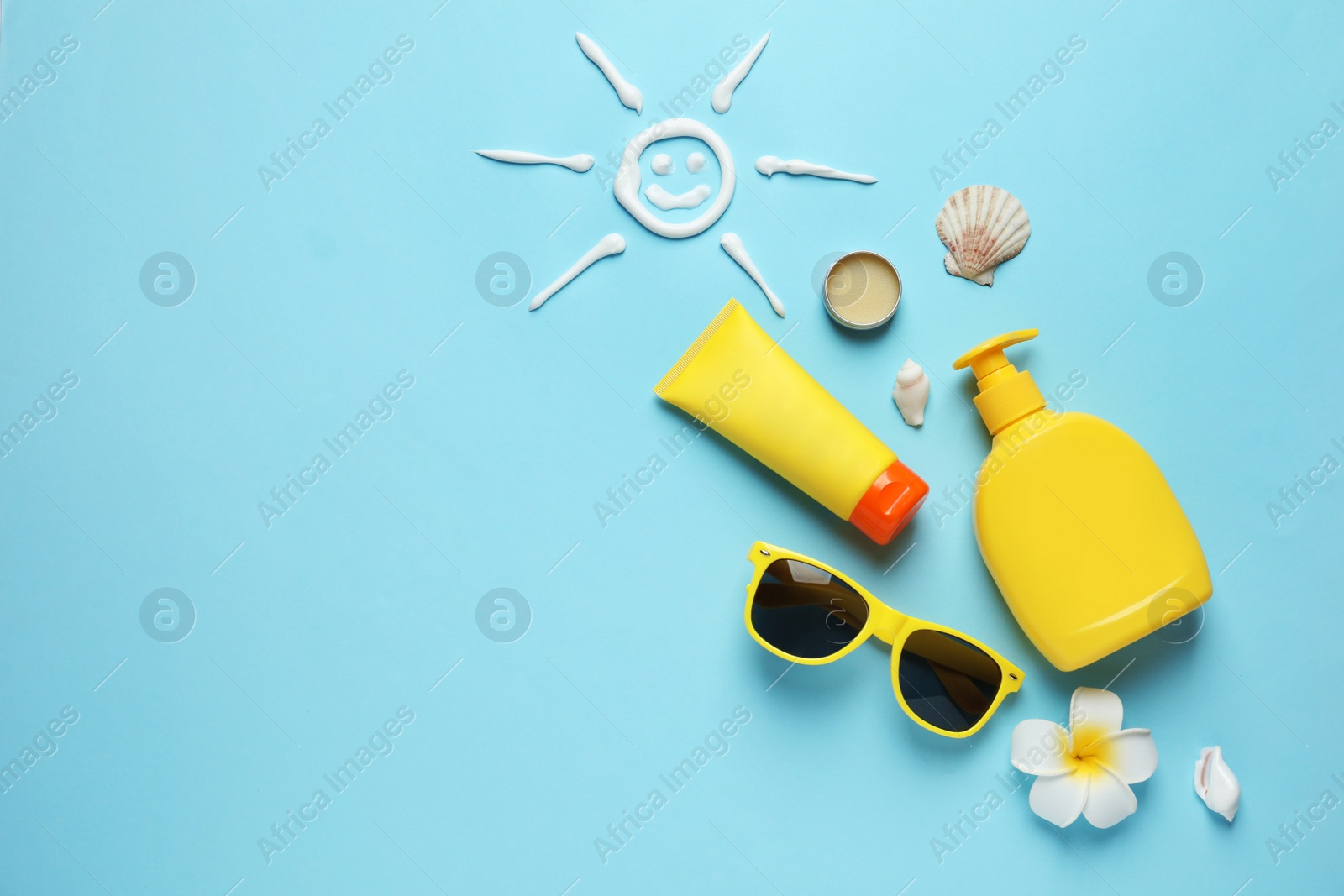 Photo of Flat lay composition with sun protection cosmetic products on blue background, space for text