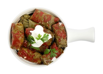 Photo of Delicious stuffed grape leaves with sour cream and tomato sauce on white background, top view