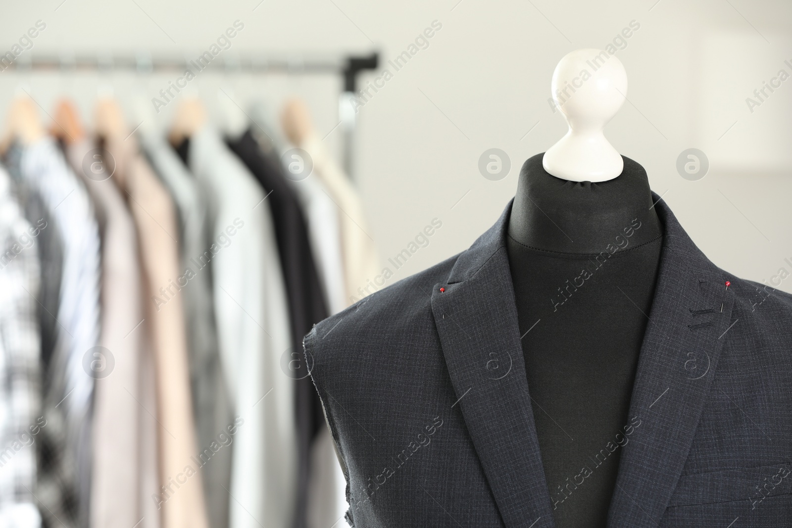 Photo of Mannequin with unfinished jacket in tailor shop, closeup. Space for text