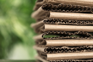 Photo of Stack of cardboard for recycling on blurred background, closeup. Space for text