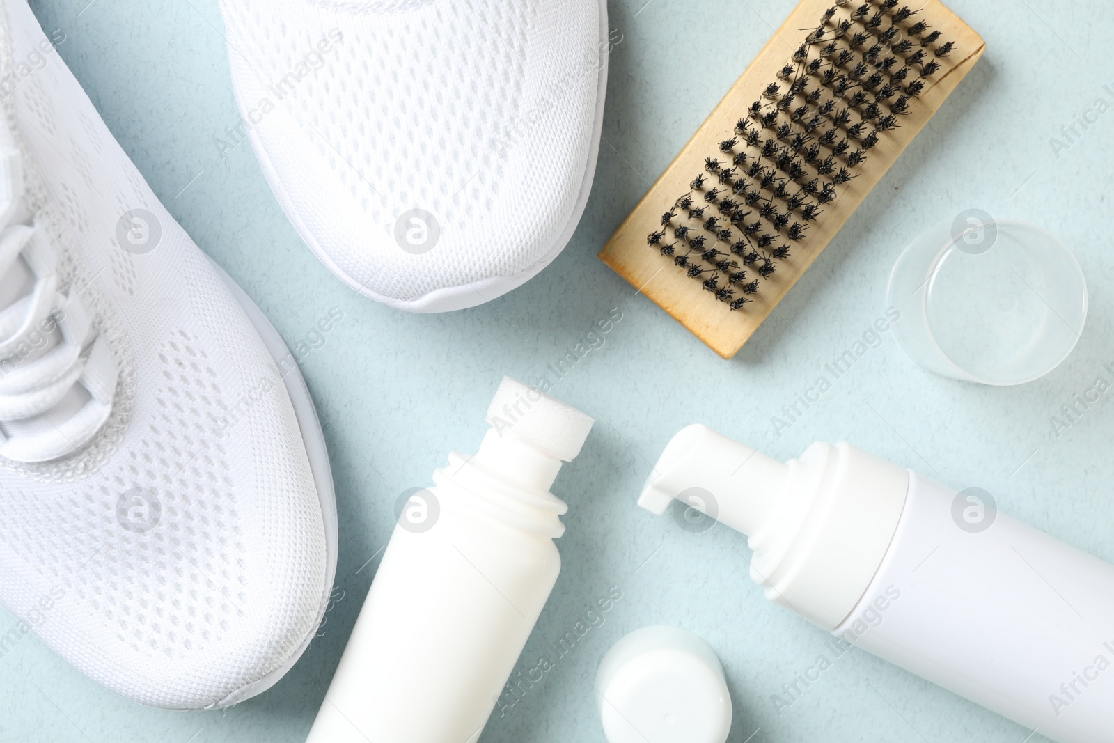 Photo of Flat lay composition with stylish footwear and shoe care accessories on light background