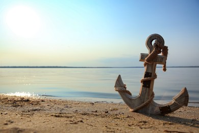 Photo of Wooden anchor on river shore near water