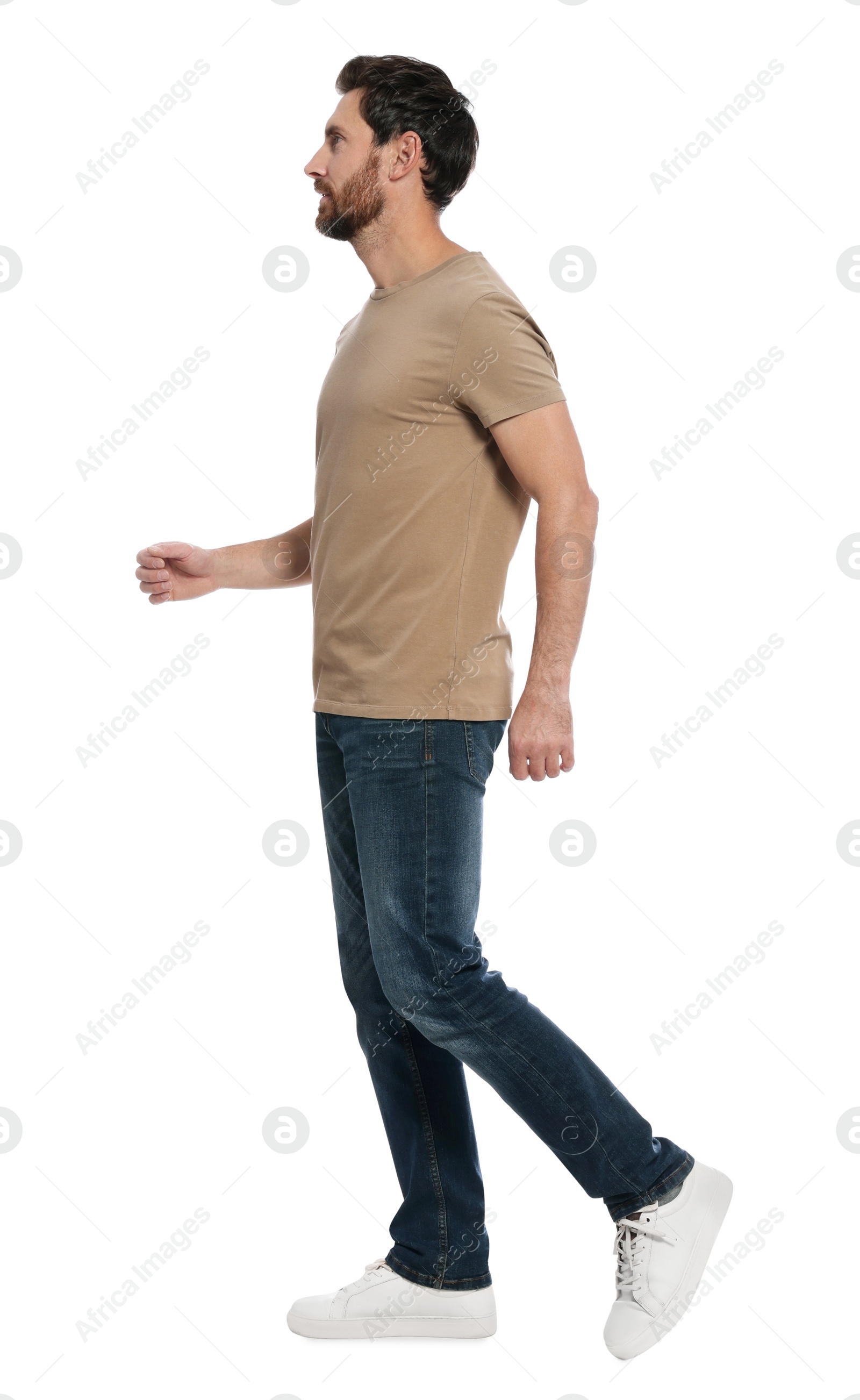 Photo of Handsome man in stylish outfit walking on white background