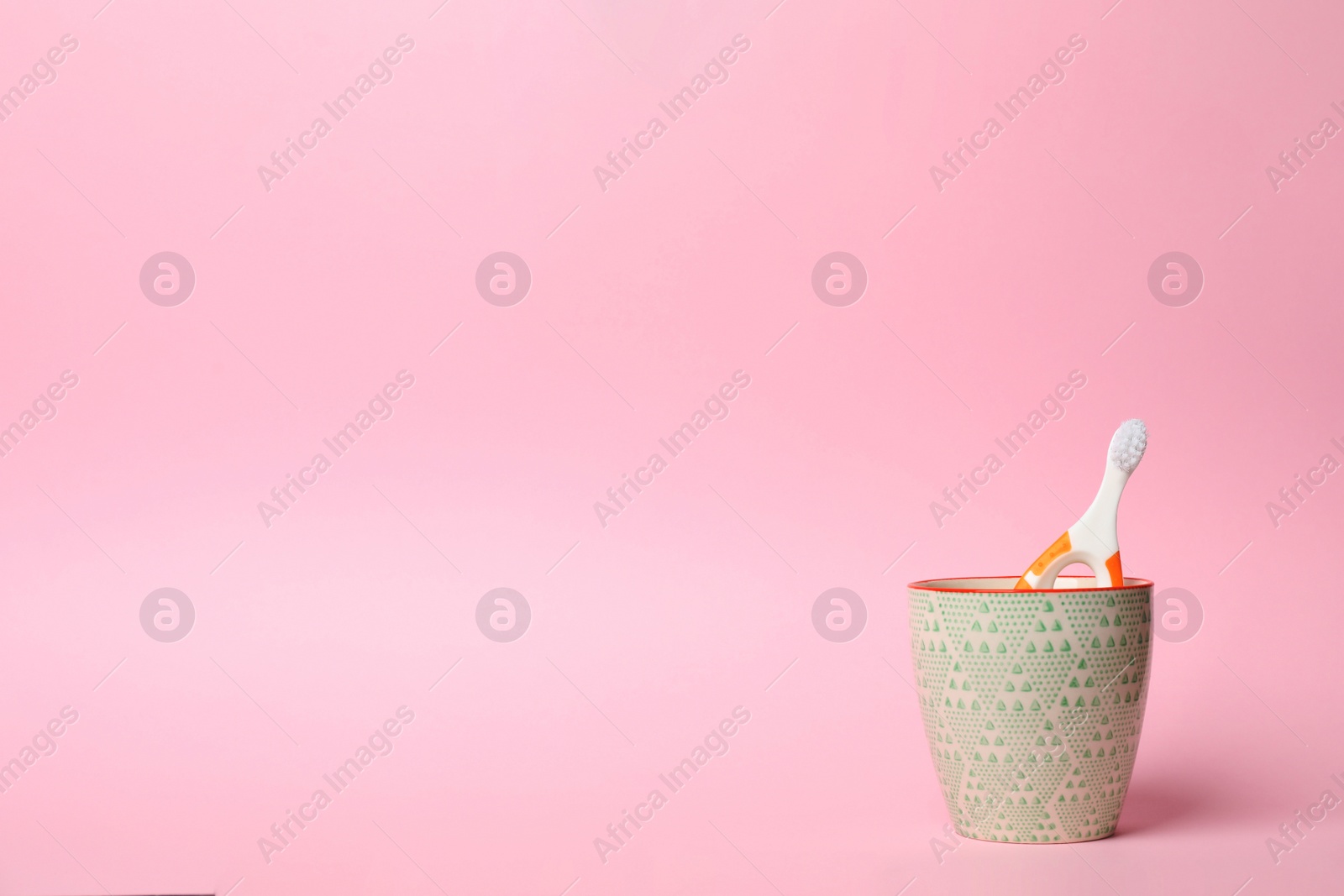 Photo of Baby toothbrush in holder and space for text on color background