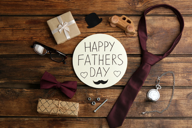 Photo of Flat lay composition of greeting card HAPPY FATHER'S DAY on wooden background
