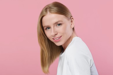 Portrait of beautiful young woman on pink background