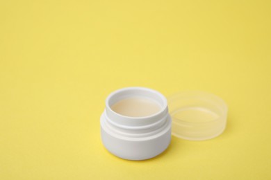 Jar of petroleum jelly on yellow background