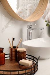 Photo of Different toiletries near vessel sink in bathroom