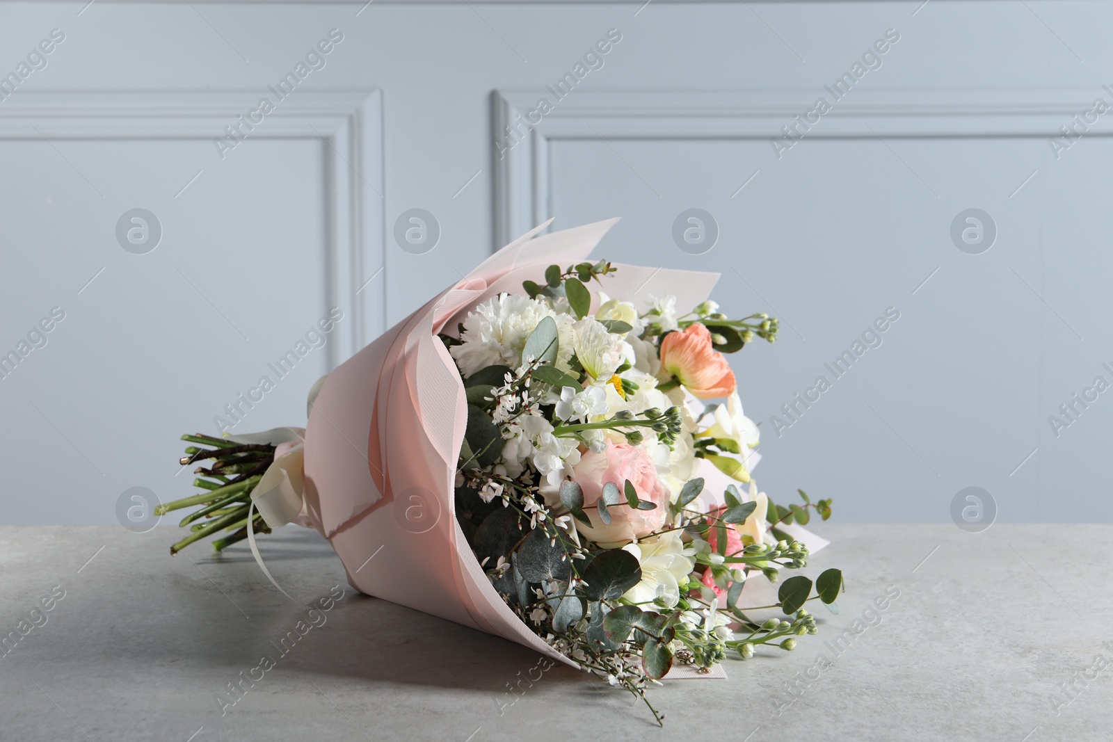 Photo of Bouquet of beautiful flowers on light grey table