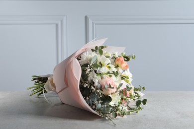 Photo of Bouquet of beautiful flowers on light grey table