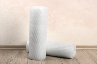 Photo of Bubble wrap rolls on floor near pink wall