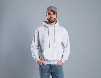 Photo of Portrait of young man in sweater on grey background. Mock up for design