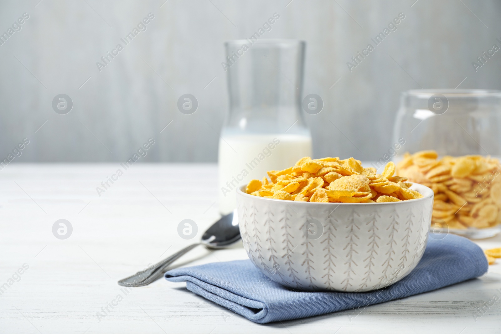 Photo of Tasty corn flakes on white wooden table