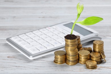 Photo of Stacks of coins with flower and calculator on white wooden table, space for text. Investment concept