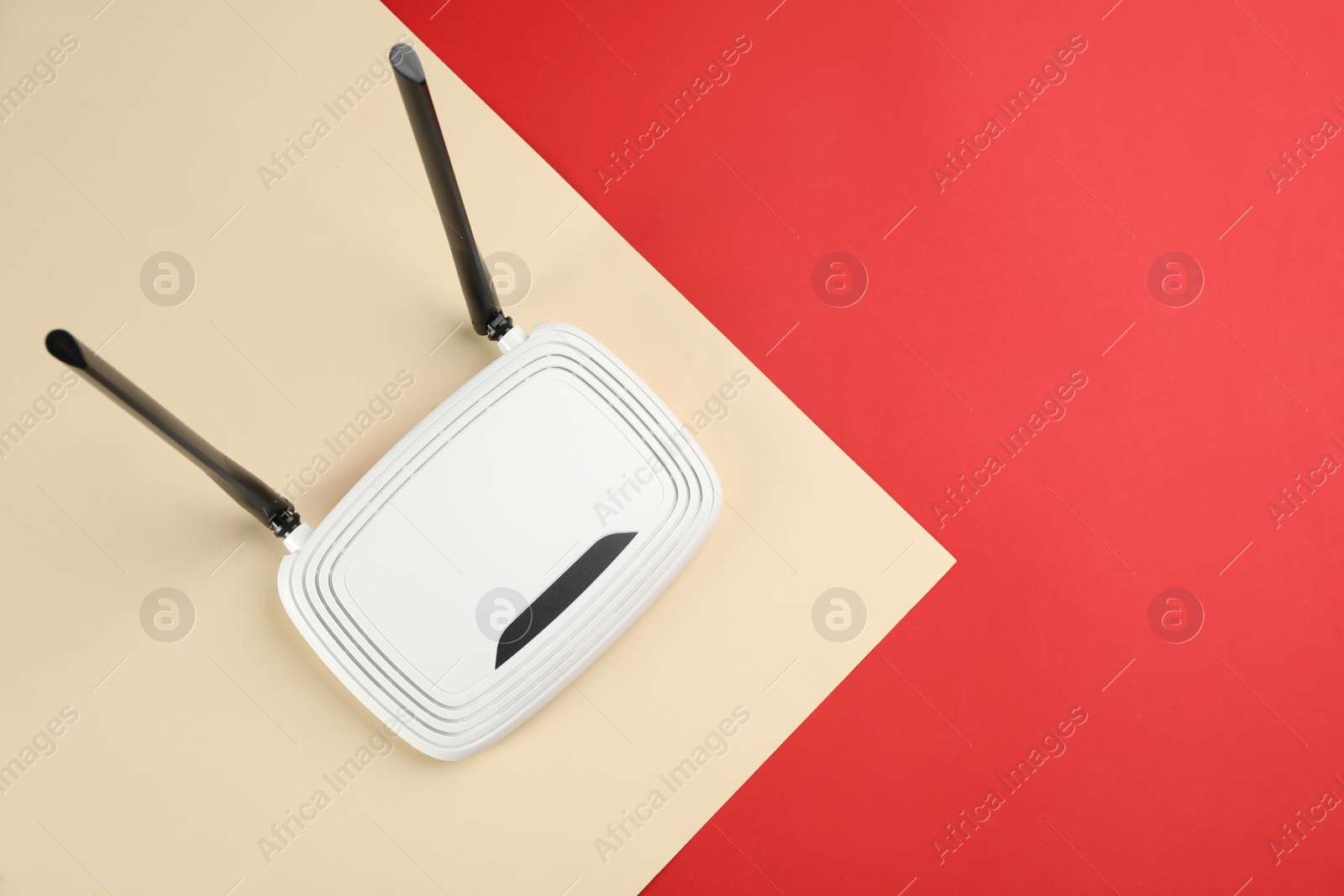 Photo of Modern Wi-Fi router on color background, top view. Space for text