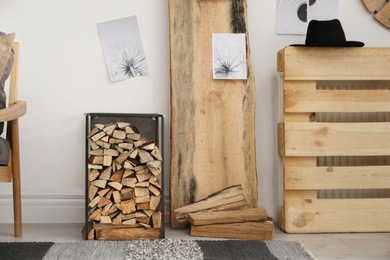 Firewood as decorative element in stylish room interior