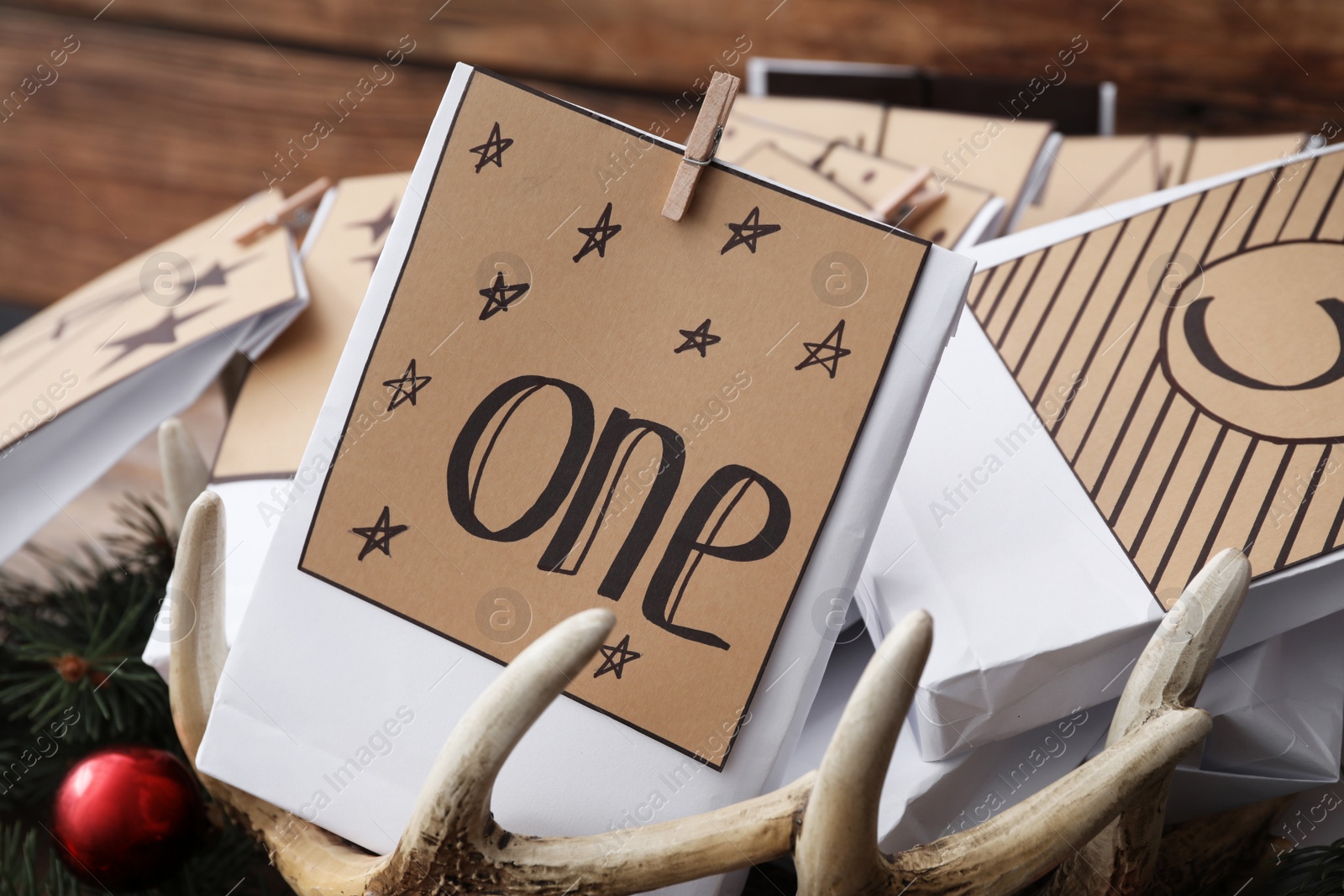 Photo of Paper bags and festive decor on wooden background, closeup. Christmas advent calendar