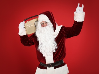 Santa Claus with vintage radio on red background. Christmas music