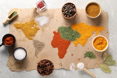 Photo of World map of different spices and products on light grey marble table, top view