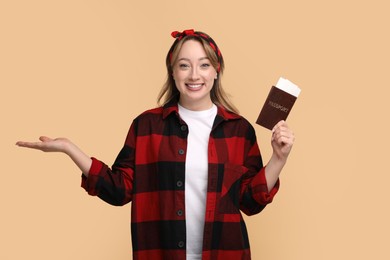 Happy young woman with passport and ticket on beige background