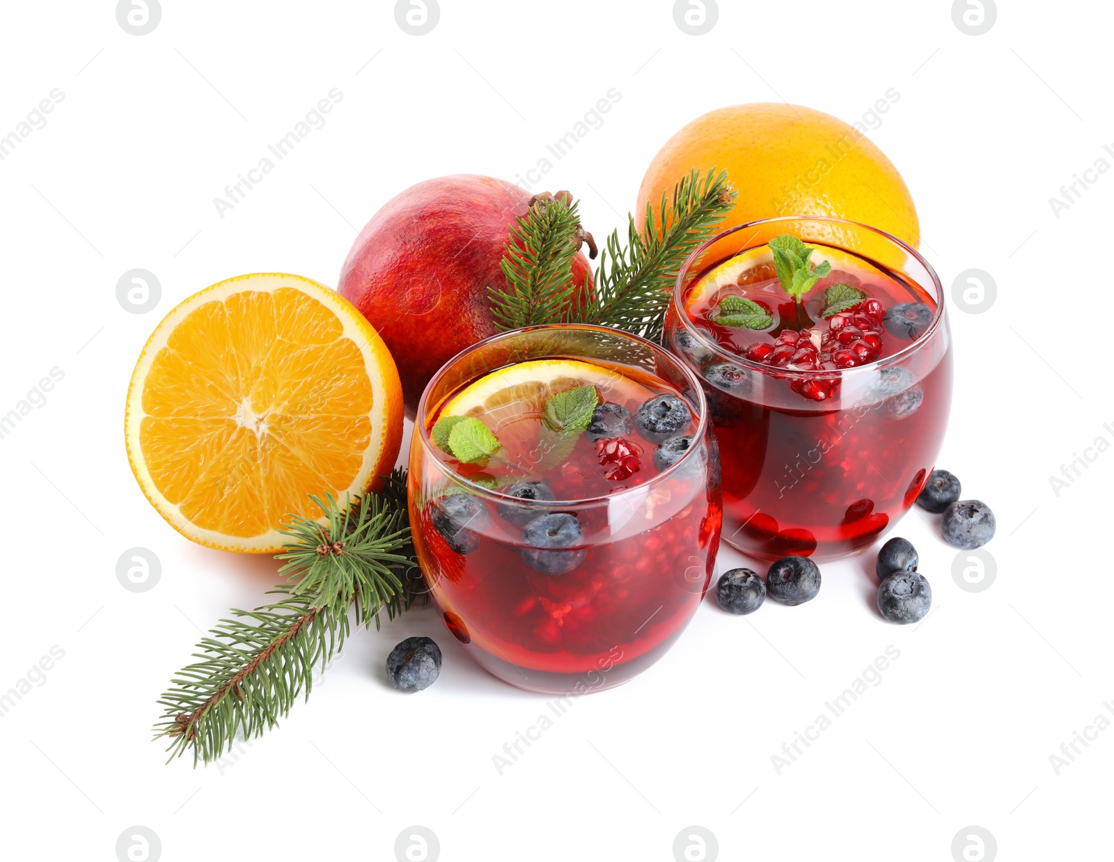 Photo of Aromatic Christmas Sangria drink in glasses, fir branches and ingredients isolated on white