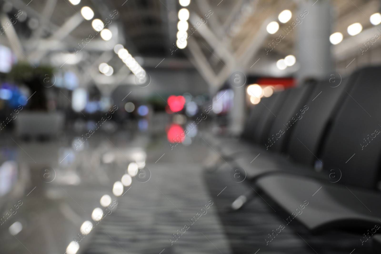 Photo of Blurred view of waiting area with seats in airport terminal