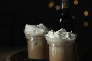Photo of Glasses of iced coffee and chocolate against blurred lights, closeup. Space for text