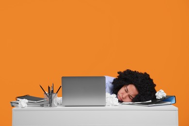 Stressful deadline. Tired woman lying on white desk against orange background. Space for text