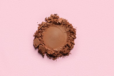 Photo of Crushed eye shadow on pink background, top view