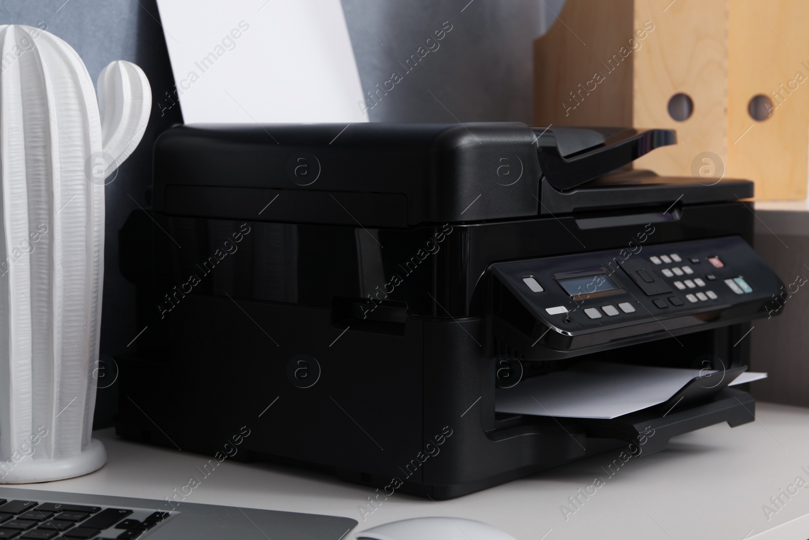 Photo of Modern printer and decor element on white table