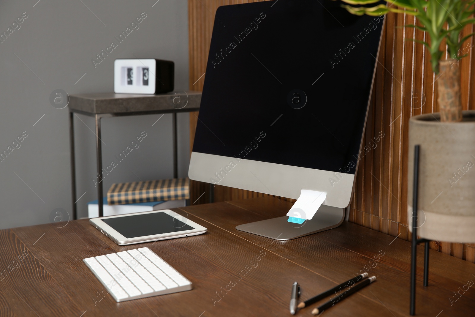 Photo of Stylish workplace with modern computer near wooden wall. Space for text