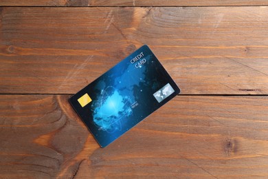 Photo of One credit card on wooden table, top view
