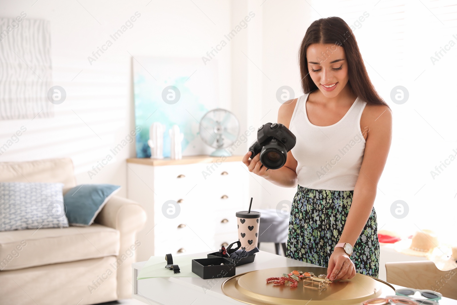 Photo of Young photographer taking picture of jewelry indoors