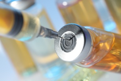 Filling syringe with orange medication from glass vial, closeup