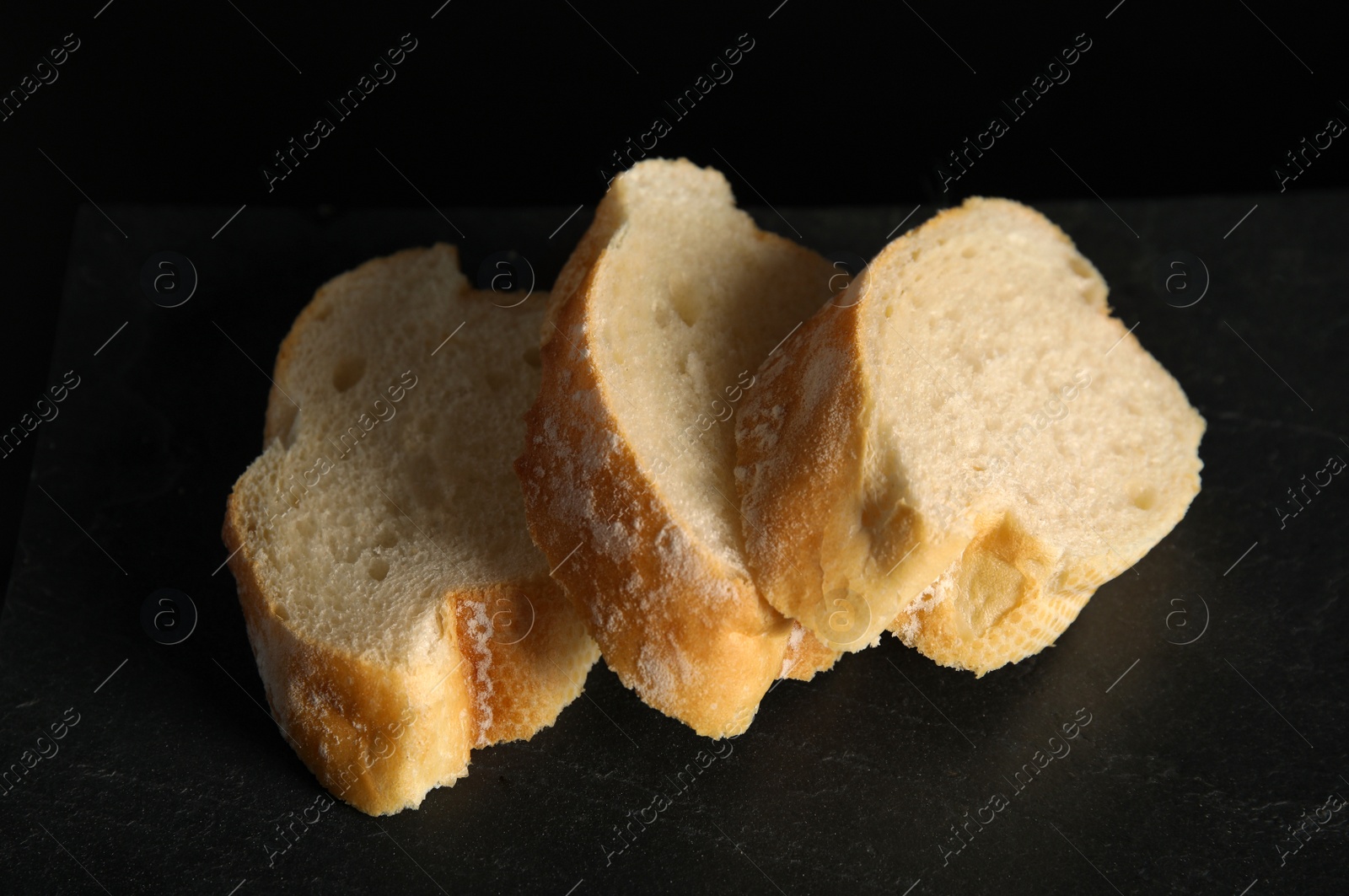 Photo of Tasty sliced wheat bread on black table