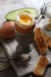 Photo of Soft boiled egg served for breakfast on wooden table