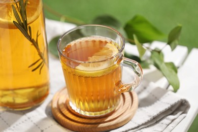 Glass cup of tasty iced tea with lemon on table, closeup
