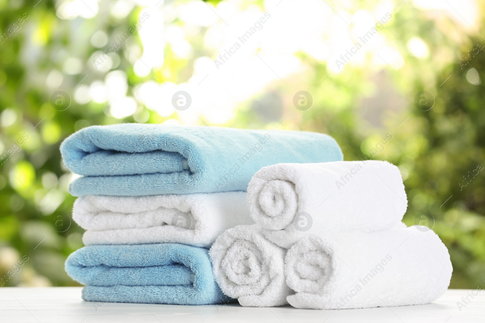 Photo of Soft bath towels on table against blurred background