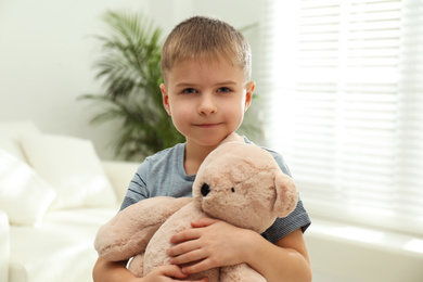 Photo of Little boy with toy bear at home